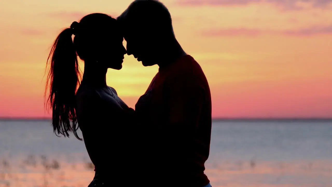 Casal abraçado ao pôr do sol